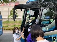 1人ずつ並んで観光バスに乗り込んでいく生徒たちの写真