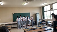 黒板を背にして、5人の生徒が横に並んでいる様子の写真