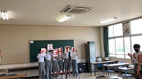 5人の生徒が赤文字で「FIGHT」と書かれた紙をそれぞれ両手で掲げている様子の写真