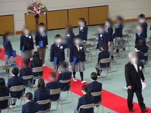 赤い絨毯の上を歩いて、手には卒業証書を持った卒業生達の写真