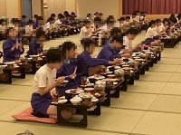 生徒たちが一方向を向き感染対策をしっかりして食事をしている様子の写真