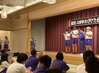 舞台上で4人の生徒たちが立っている様子の写真