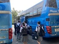 観光バスに乗り込むために並んでいる生徒たちを後ろから撮った写真