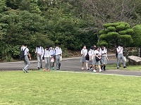 芝の広場の横のT字路を歩いている生徒たちの写真