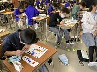 複数の生徒が絵の具で色を塗っている様子の写真