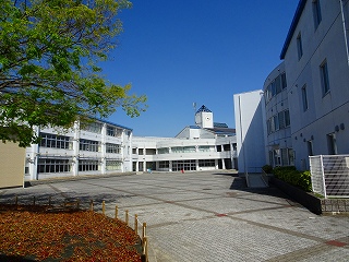 雲一つない青空と富士中学校校舎を中庭から撮影した写真
