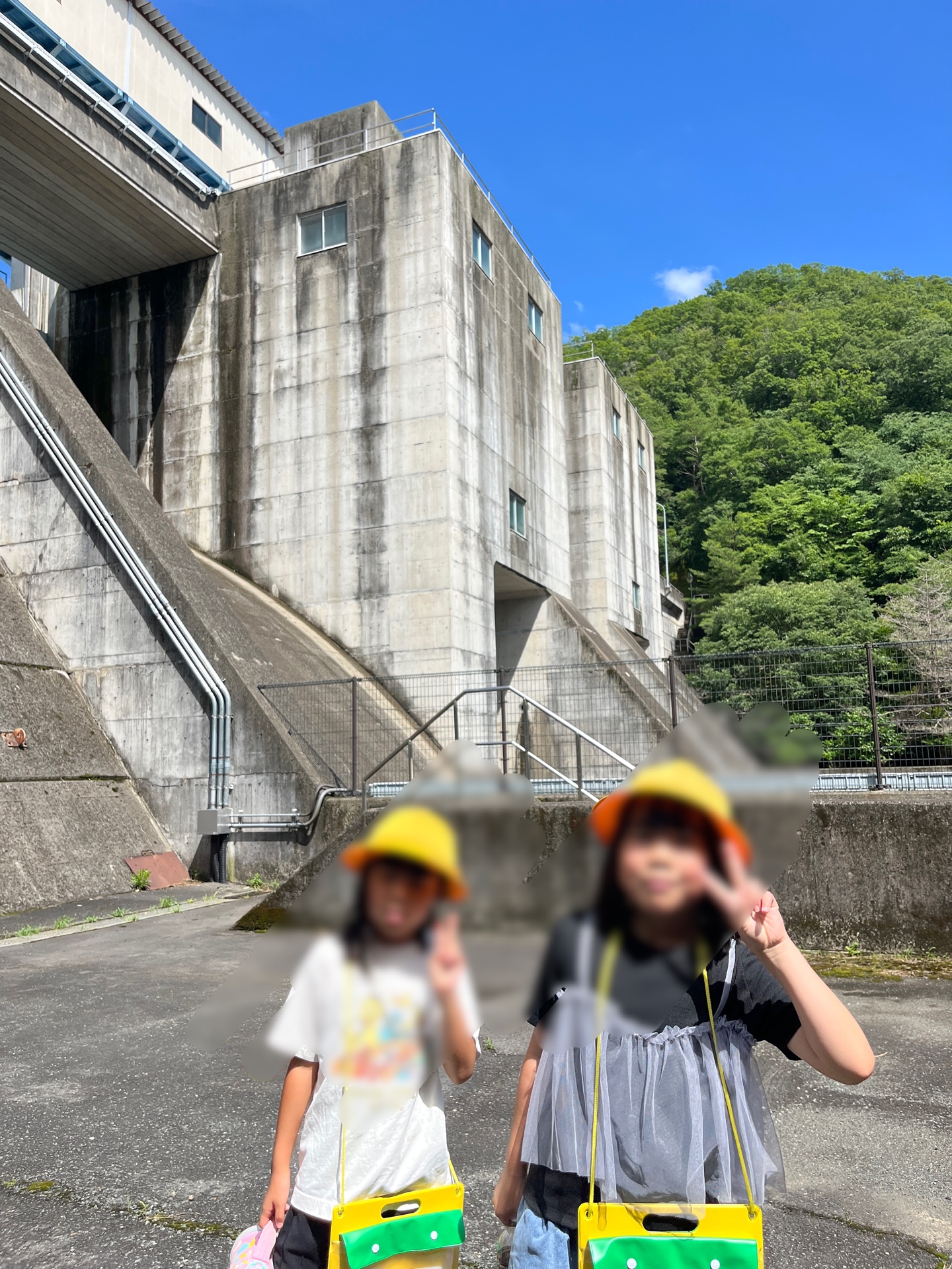 ダムをバックに写真